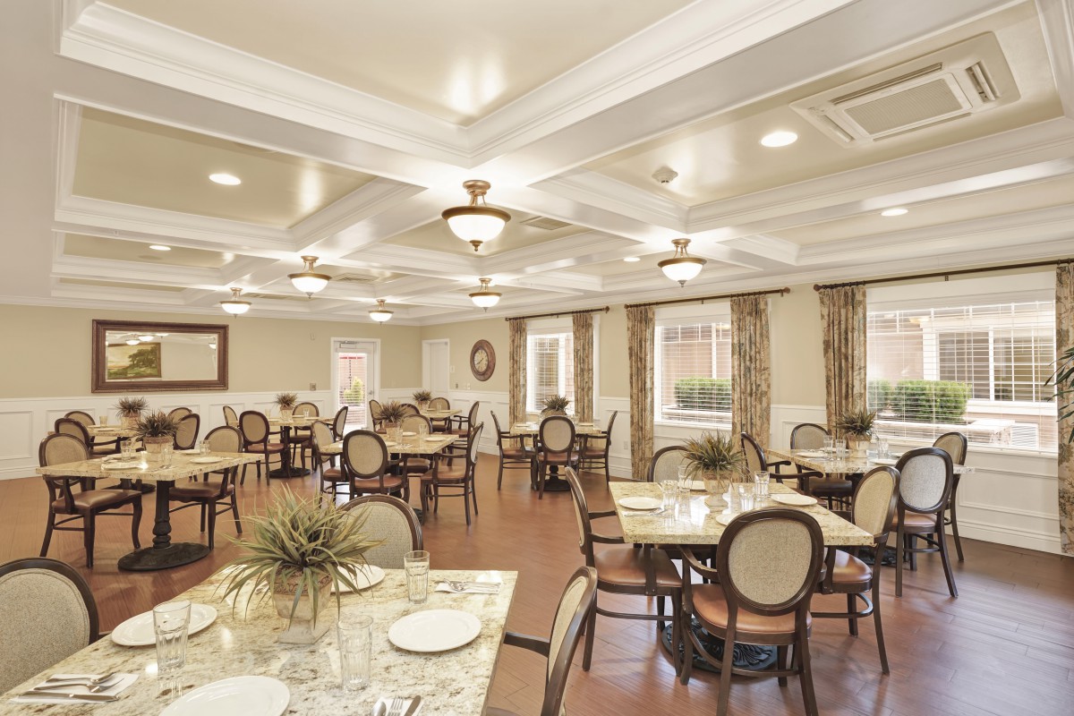 A spacious and elegantly decorated dining room with neatly arranged tables and chairs.