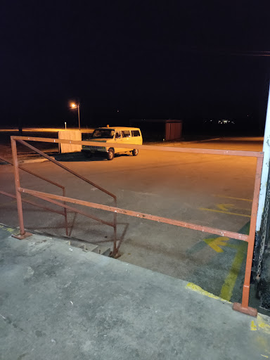 A quiet night scene in a parking lot, featuring a van parked under the glow of streetlights.