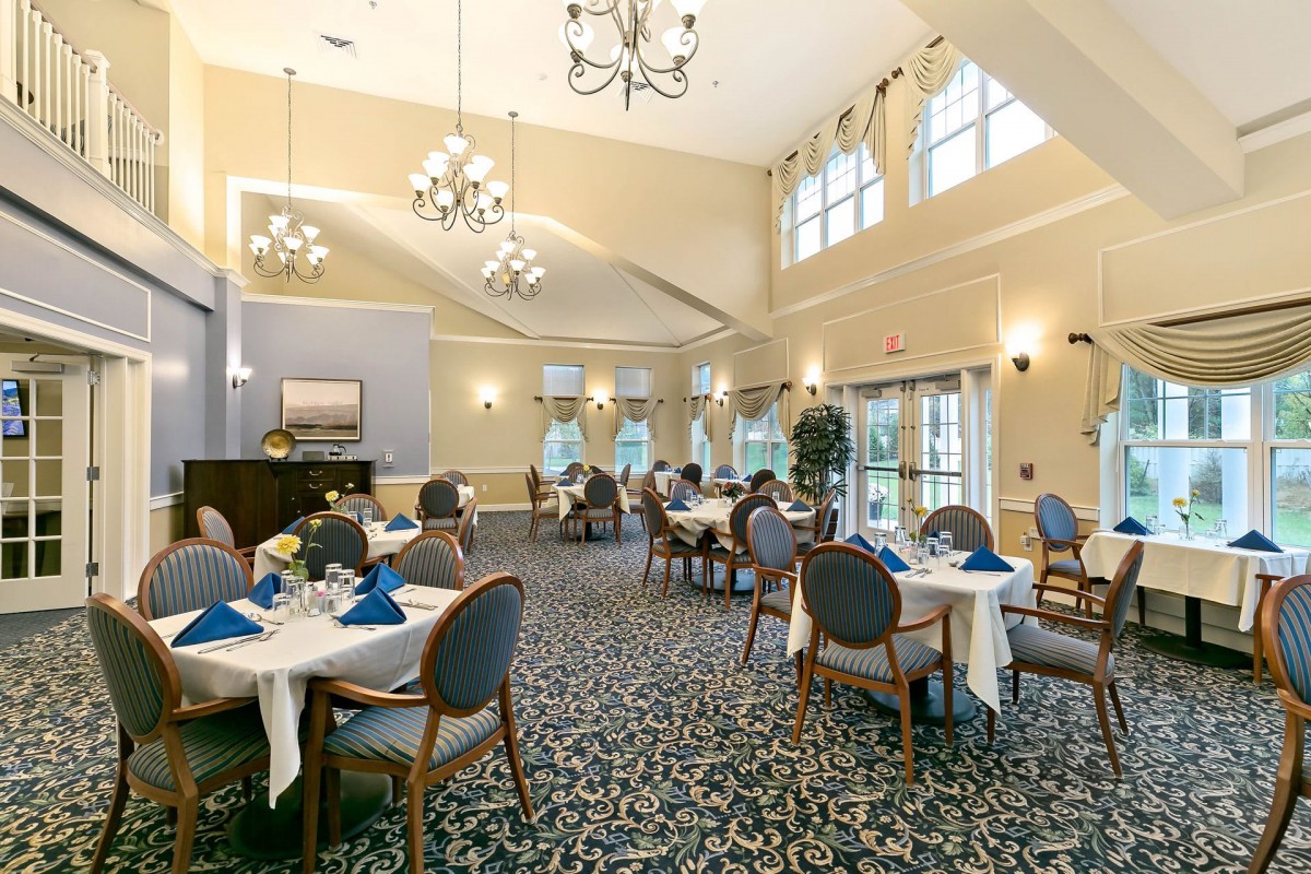 An elegant dining room with chandeliers and neatly arranged tables.