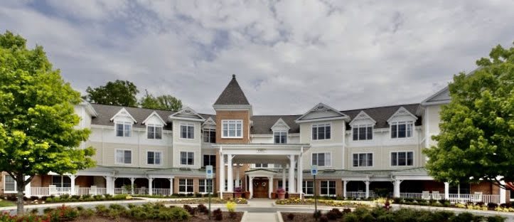 A symmetrical residential building with a central tower and well-kept landscaping.