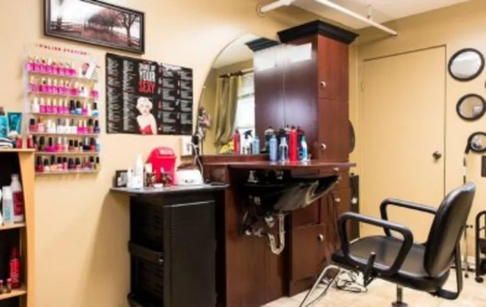 A cozy barbershop interior with a styling station, mirror, and hair care products.