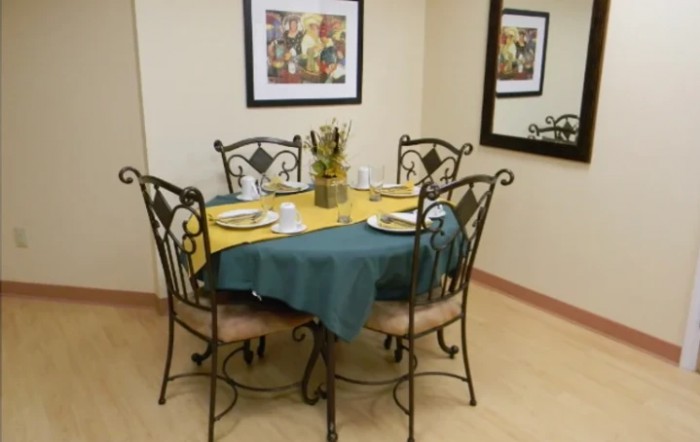 A cozy dining area with a set table and elegant wrought iron chairs.