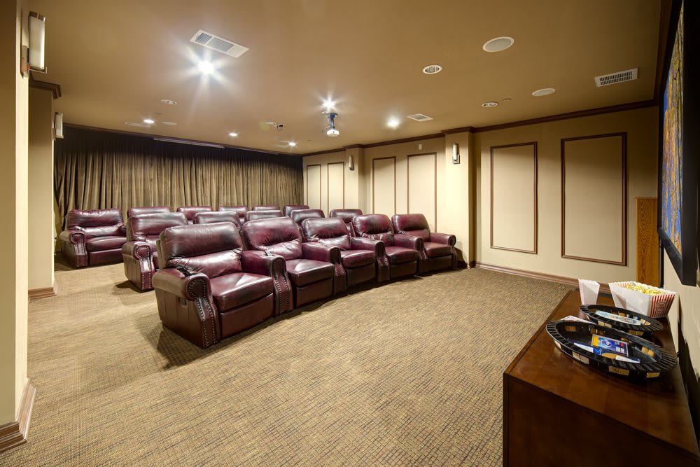 A luxurious home theater with leather seating arranged in rows.
