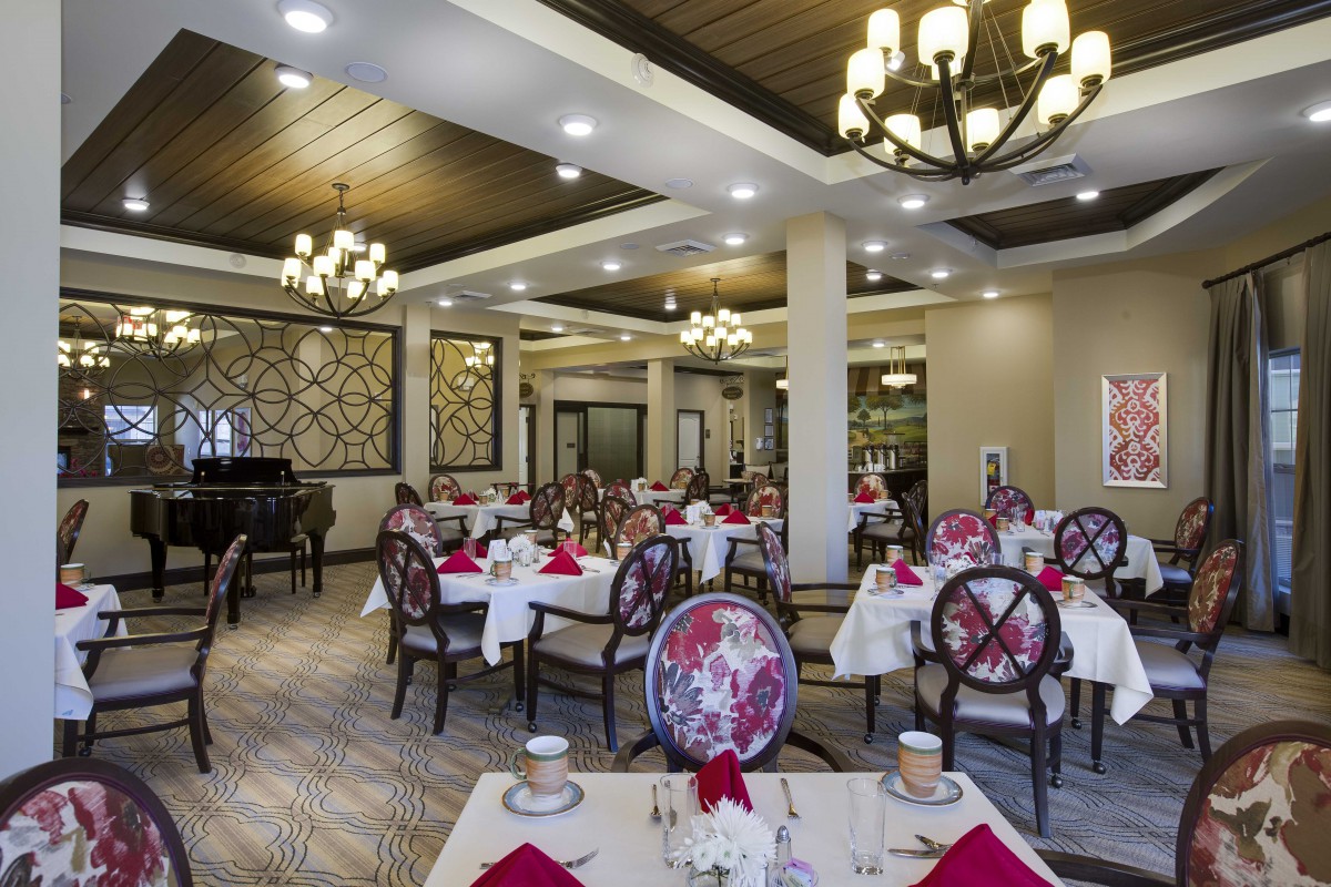 An elegant restaurant dining area with chandeliers and neatly arranged tables.