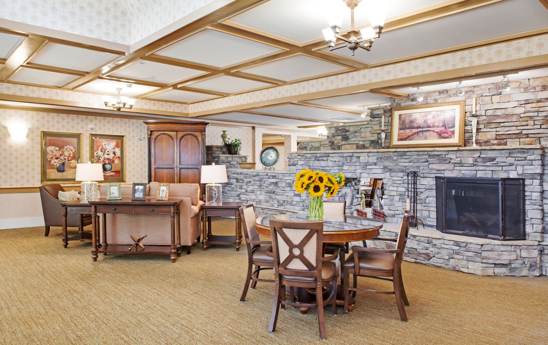 A cozy living room with a stone fireplace and a dining table adorned with sunflowers.