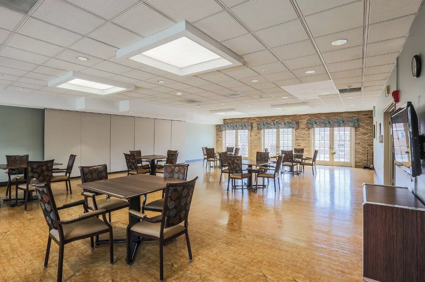 A spacious dining area with wooden floors and ample natural light.