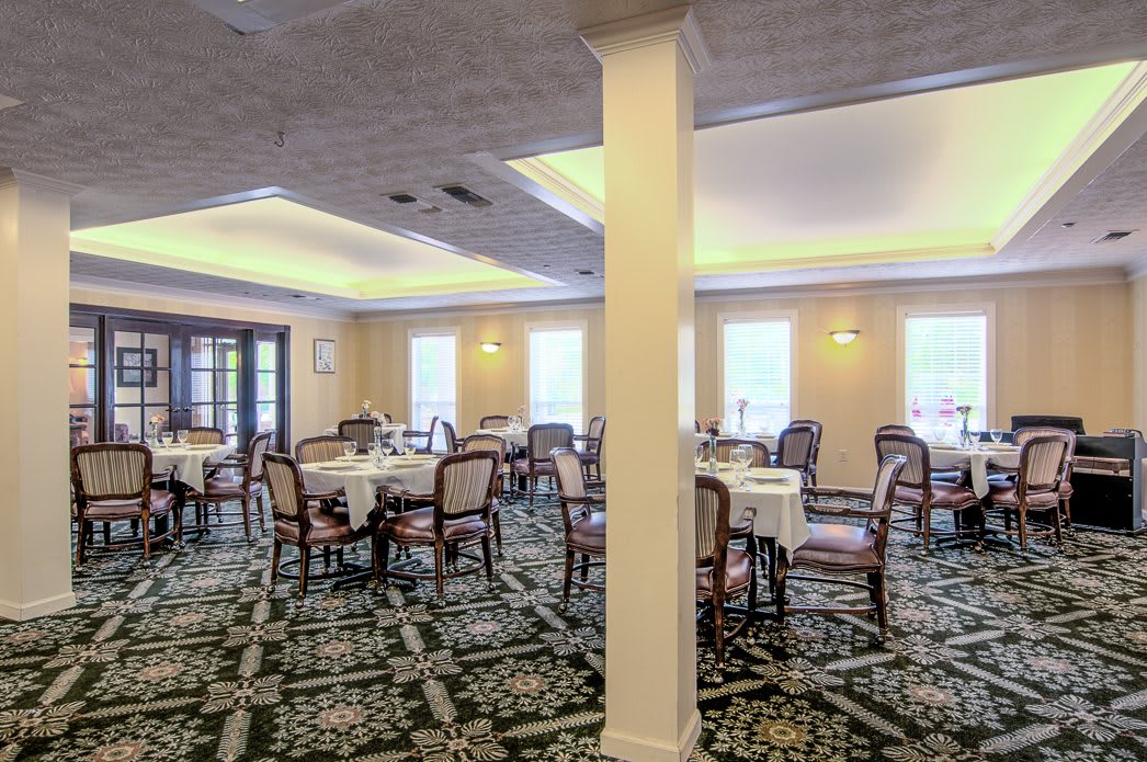 A spacious dining room with neatly arranged tables and soft lighting.