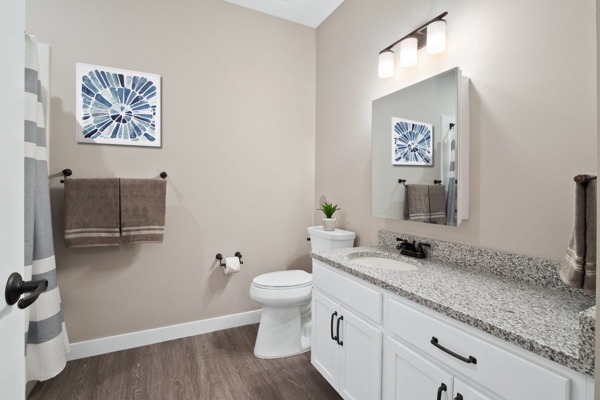 A modern bathroom interior featuring a toilet, sink, and mirror with stylish decor.