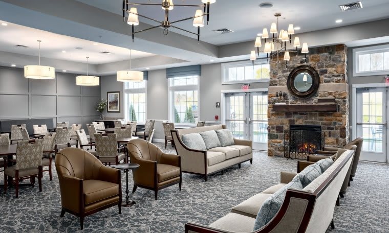 A modern and cozy living room with stylish furniture, a chandelier, and a fireplace.
