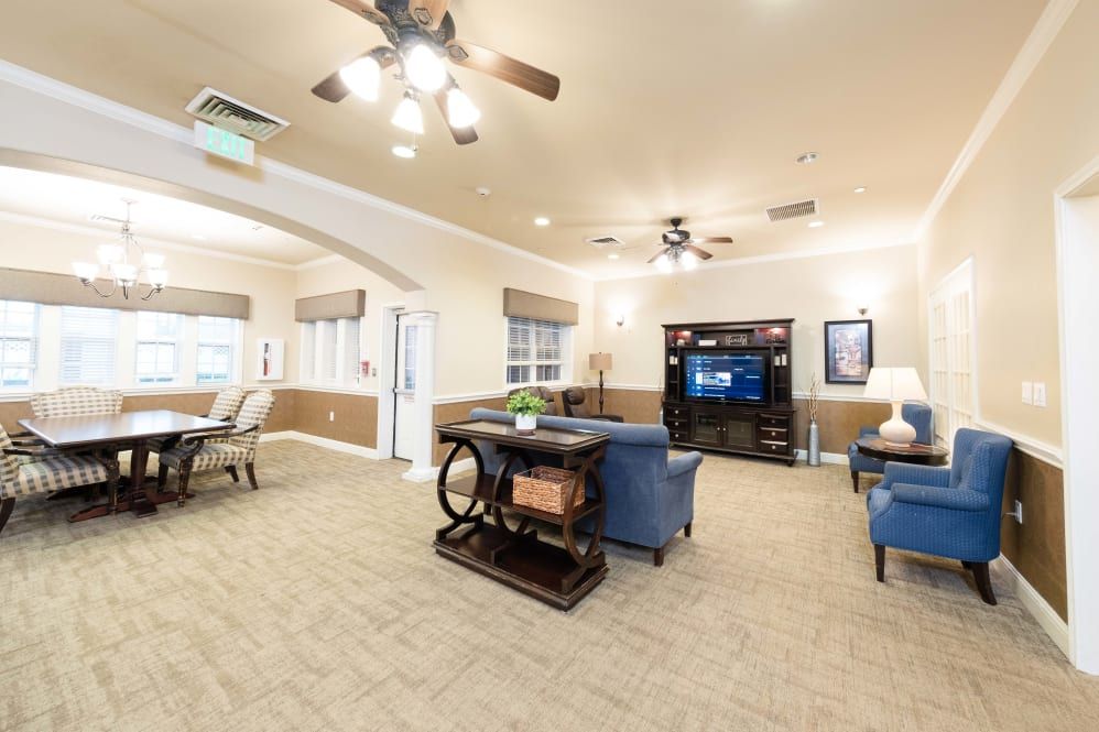 A cozy living room with comfortable furniture, a TV, and ample lighting.