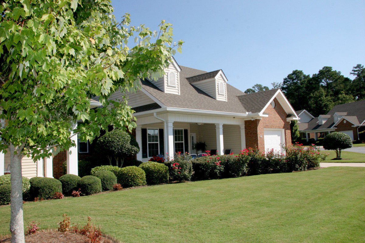 A suburban house with a well-maintained lawn and landscaping.