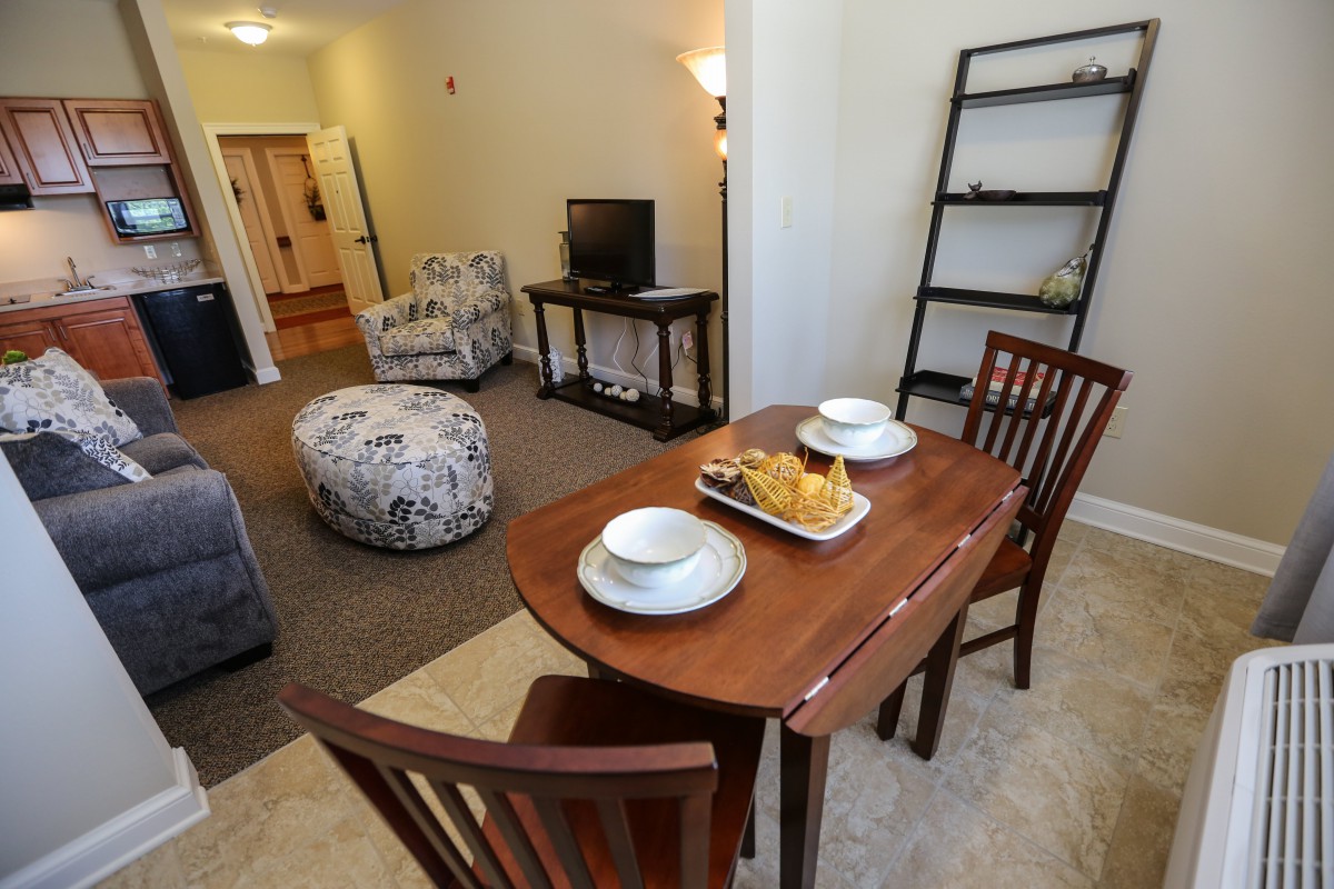 Cozy living and dining area with a small table set for two.