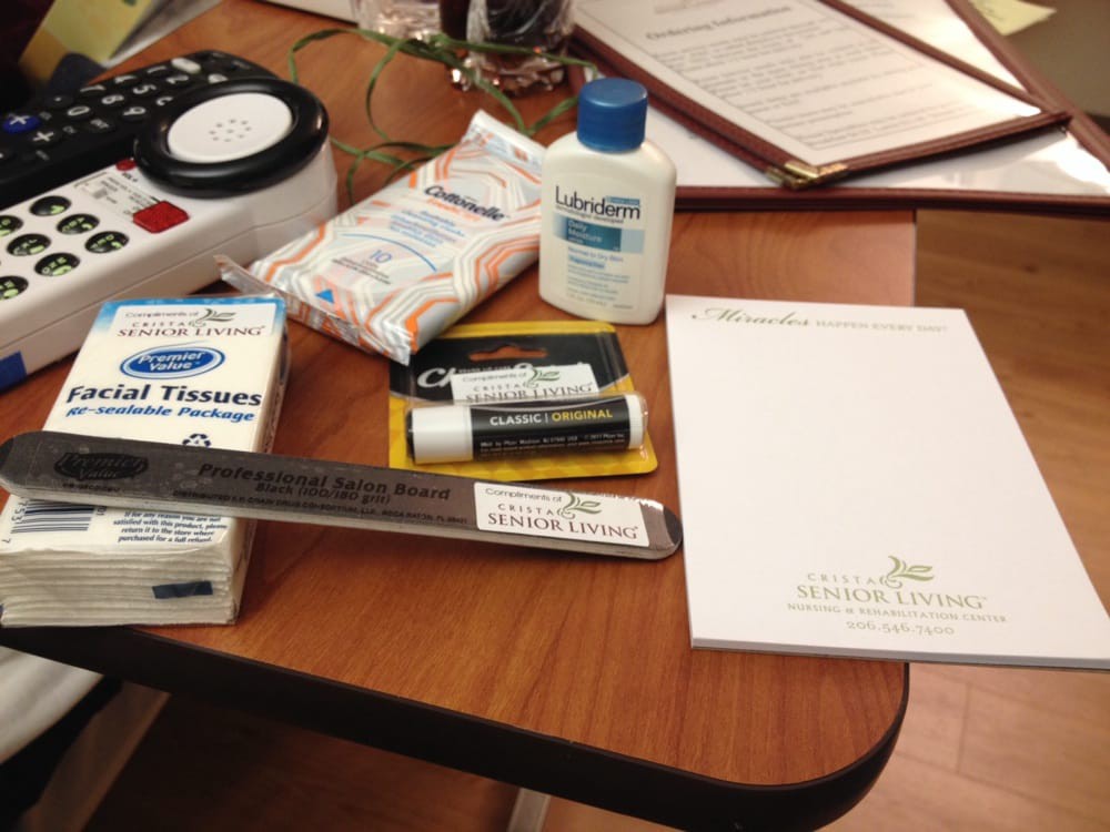 A desk with various office and personal care items including a notepad, ruler, oral medicine, lip balm, lotion, and tissues.