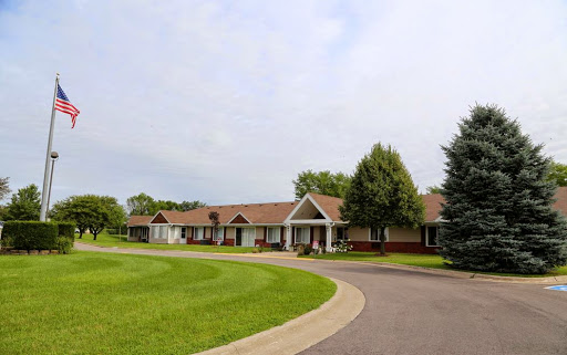 A serene residential area showcasing a single-story home surrounded by lush greenery and a winding driveway.