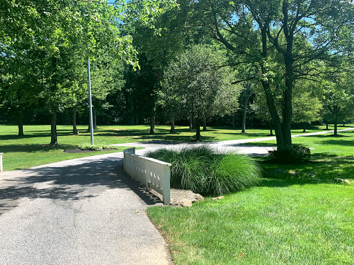 A serene pathway surrounded by lush greenery and trees, inviting visitors to enjoy nature.