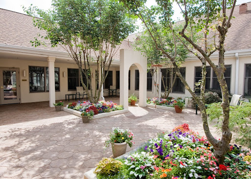 A serene courtyard filled with vibrant flowers and lush greenery.