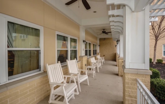 A peaceful porch with rocking chairs and ceiling fans under a covered patio.