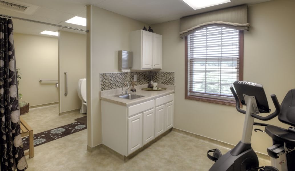 A well-lit bathroom with a sink, cabinet, and window, featuring a tile backsplash.