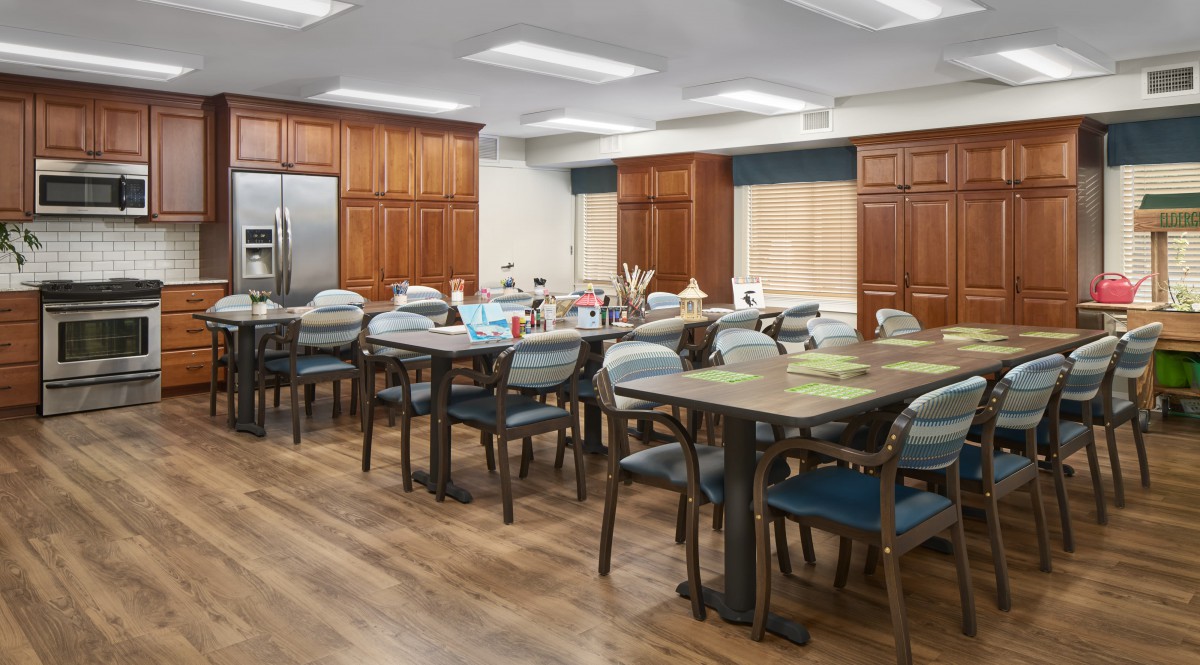 A spacious kitchen and dining area with wooden cabinets and various seating arrangements.