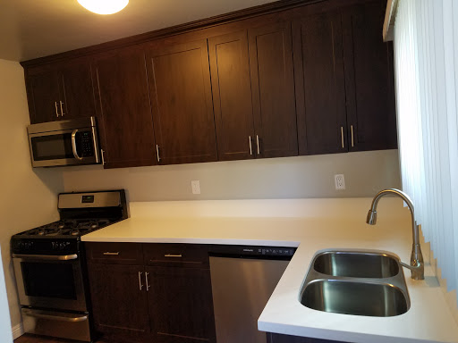 A modern kitchen featuring dark cabinetry and stainless steel appliances.