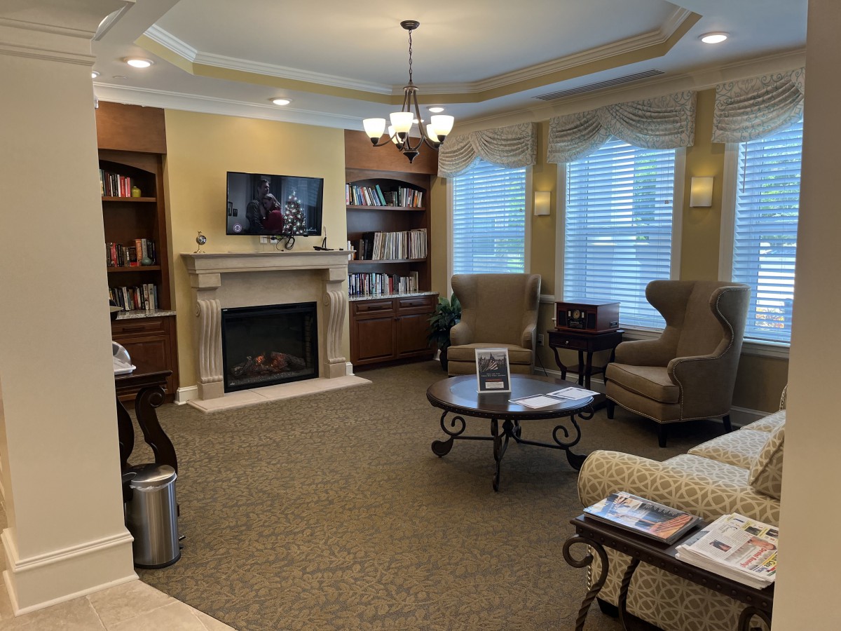 A cozy living room with a fireplace, bookshelves, and comfortable seating.