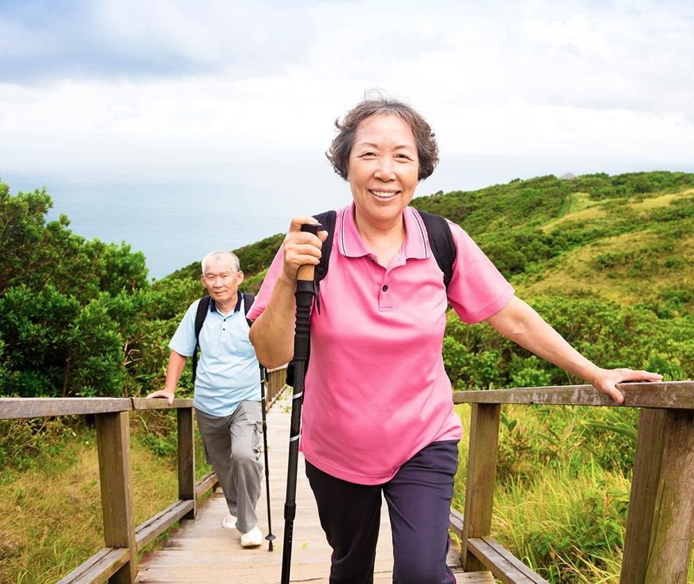 Elderly couple hiking on a scenic trail.