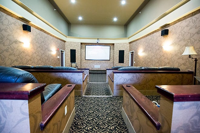 A luxurious home theater room with comfortable seating and a large projector screen.