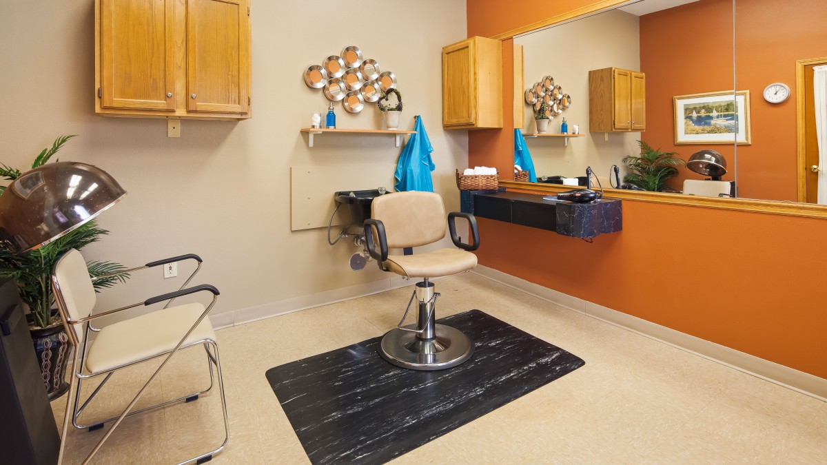 A well-organized hair salon featuring a barber chair and large mirror.