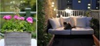 A cozy balcony garden with flowers and a cat relaxing on a cushioned seat under twinkling string lights.