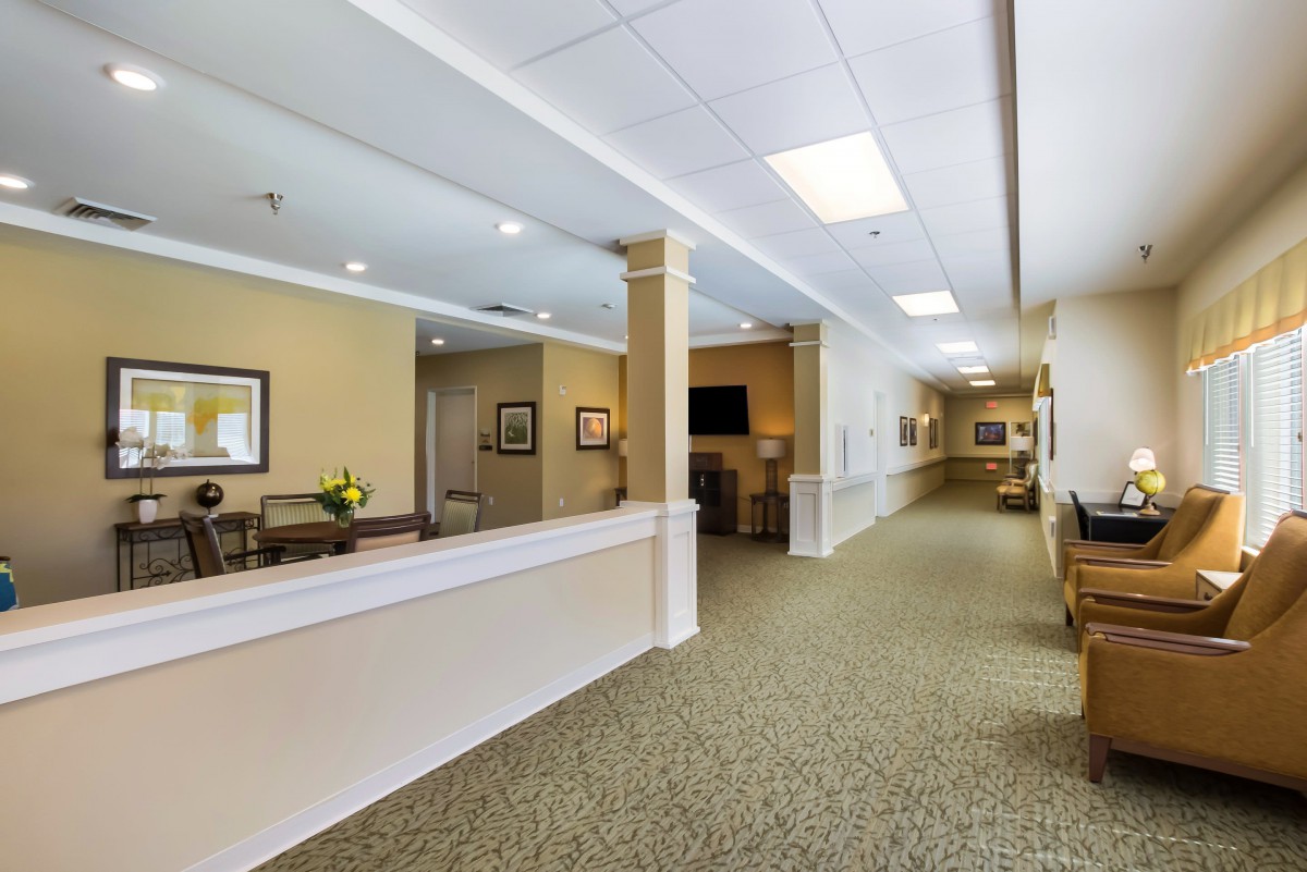 A professional office hallway with a reception area and seating.