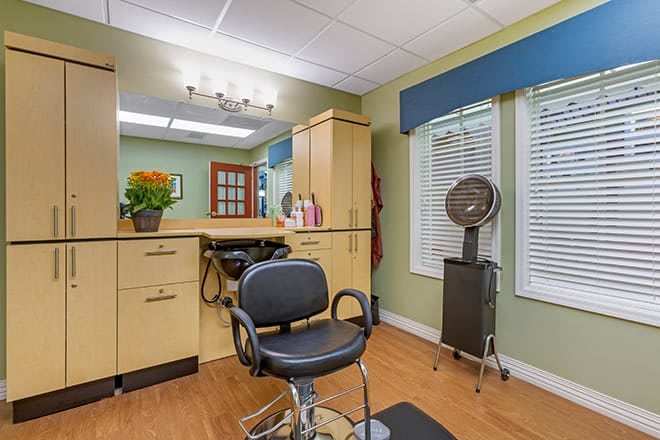 A cozy hair salon interior with a styling chair and mirror, complete with modern decor.