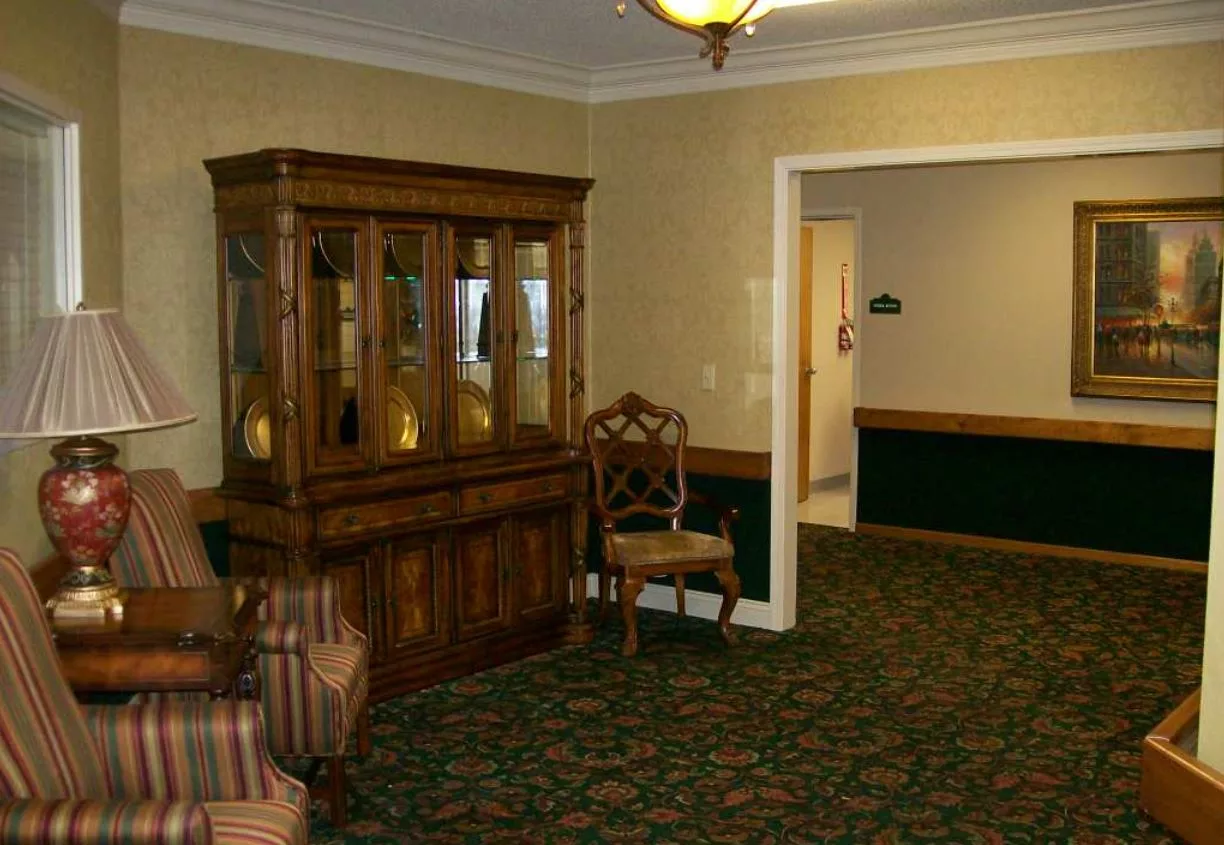 A cozy living room featuring a wooden cabinet and upholstered chair.