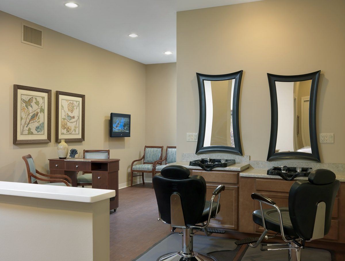 A modern salon interior featuring styling chairs and mirrors.