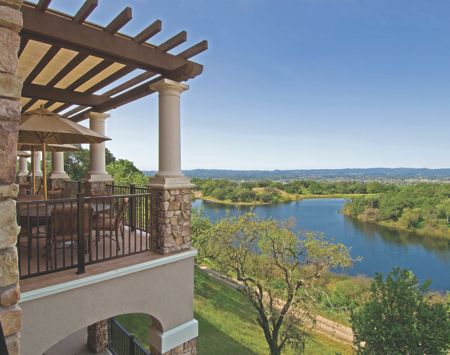 A beautiful balcony overlooking a serene lake and lush greenery.