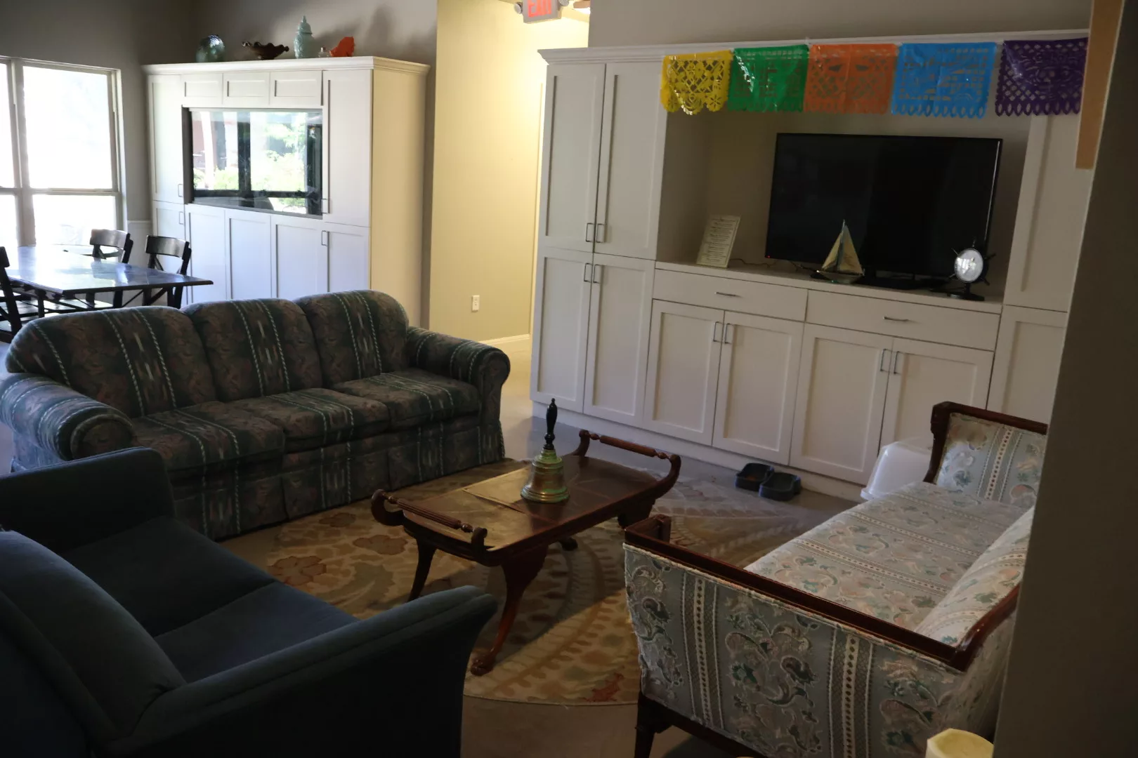 Cozy living room with sofas, a coffee table, and a television in a white cabinet.