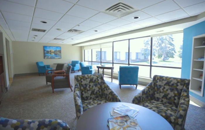 A bright and spacious lounge area with comfortable seating and large windows letting in natural light.