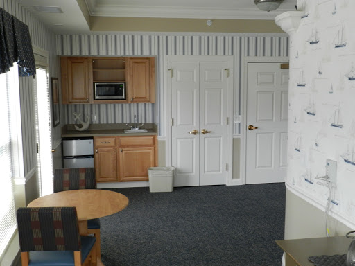 A cozy kitchenette area featuring wooden cabinets, a small dining table, and essential appliances.
