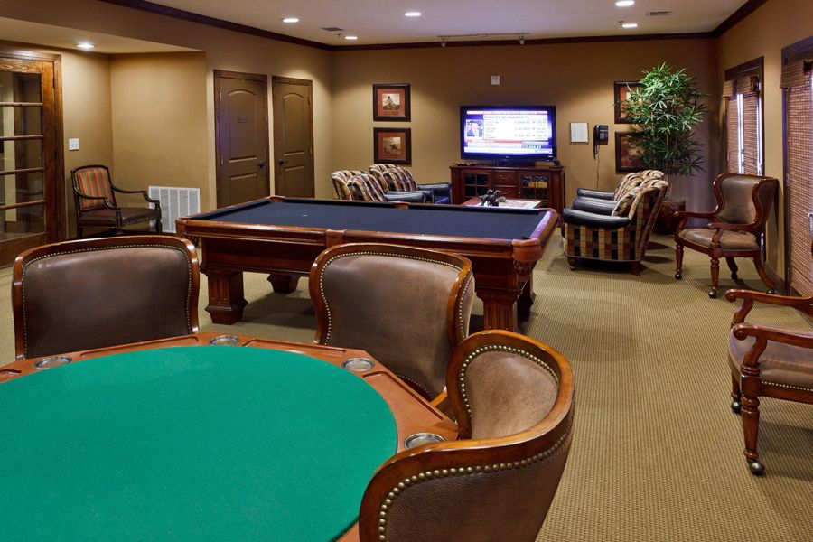 A cozy game room featuring a pool table, poker table, and a television for entertainment.