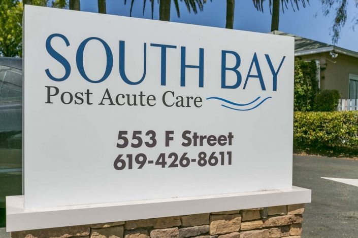A sign for South Bay Post Acute Care displaying the address and contact number.