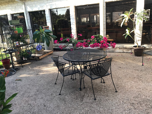 A cozy outdoor seating arrangement surrounded by vibrant flowers.