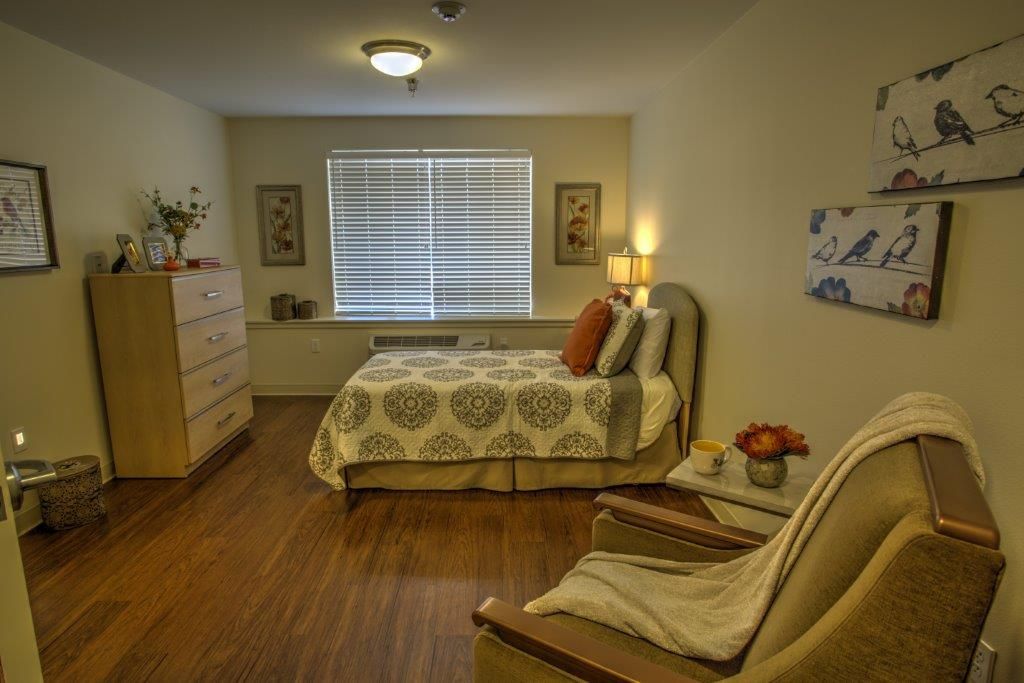 A cozy bedroom interior with warm lighting, a comfortable bed, and tasteful decor.