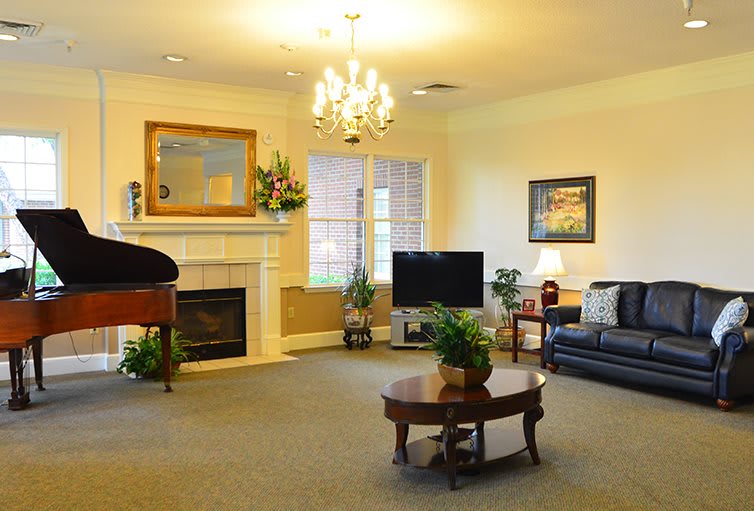 A cozy living room with elegant decor, featuring a chandelier, fireplace, and comfortable seating.