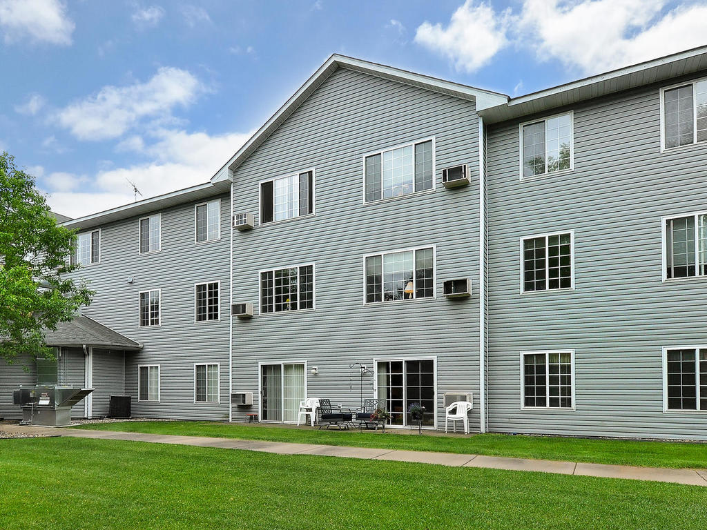 A residential apartment building with a well-maintained lawn.