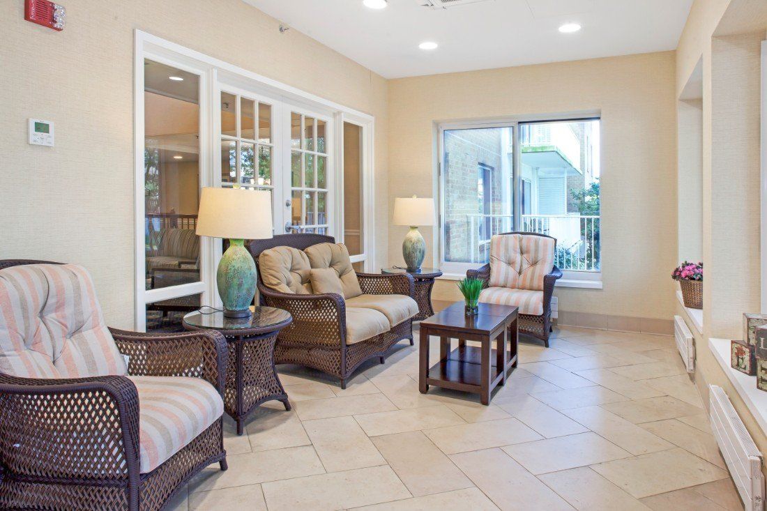 A cozy living room with comfortable seating, tables, and large windows providing natural light.