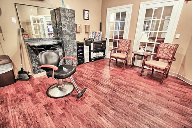 A cozy salon interior with a stylist chair and waiting area.