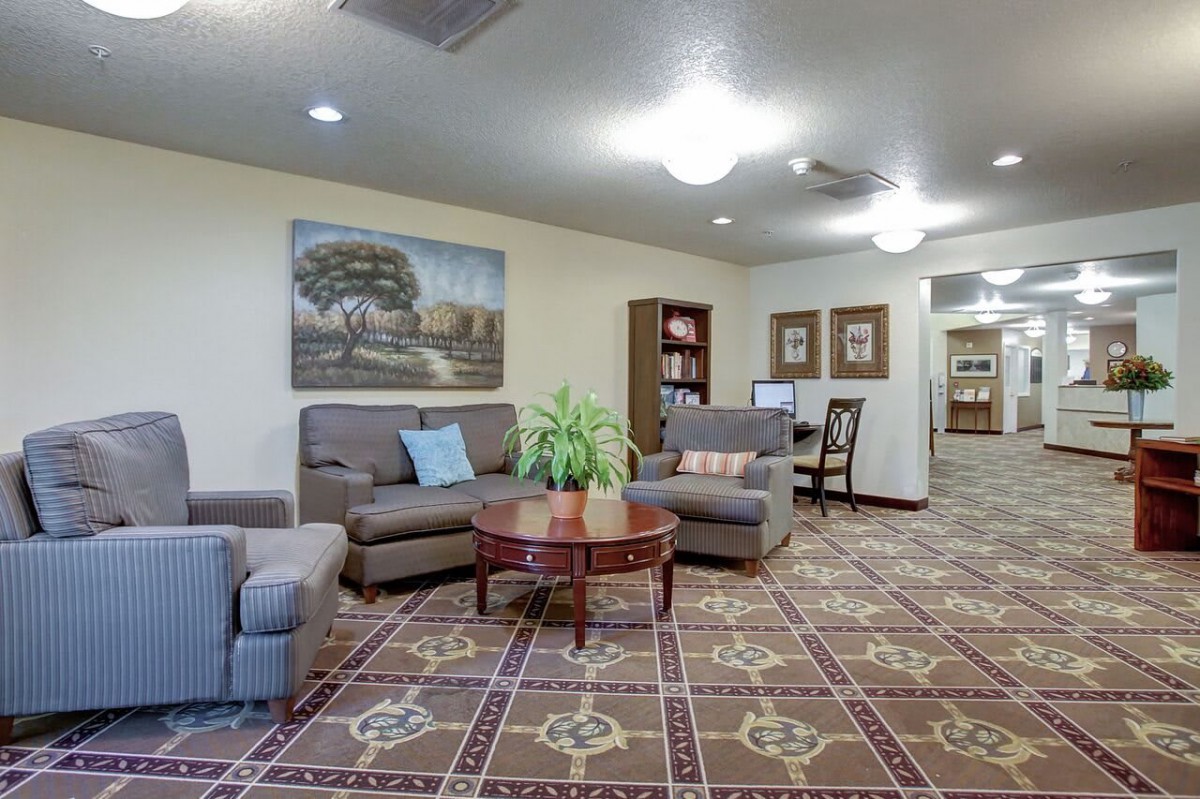 A cozy living room with comfortable seating, a central coffee table, and bookshelves.