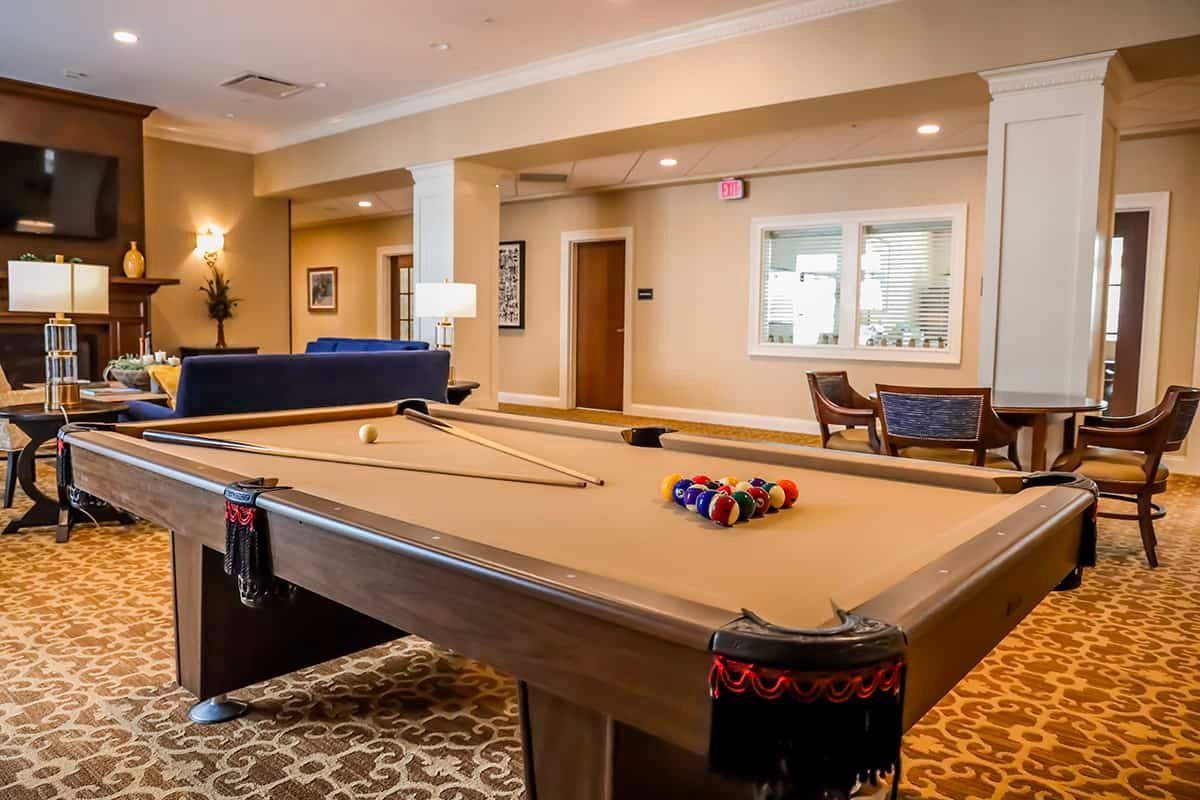 A cozy game room featuring a billiards table and comfortable seating.