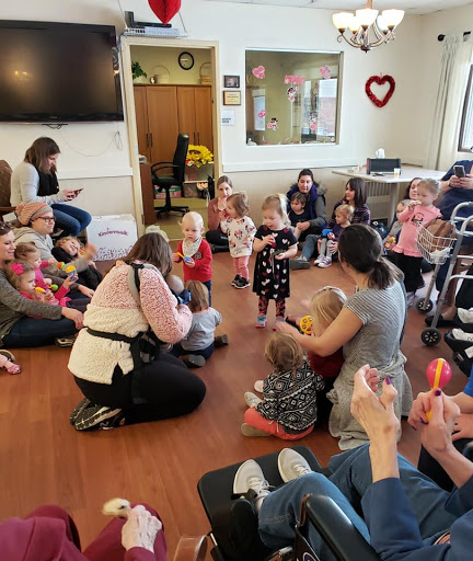 A lively gathering with children and adults sharing moments of joy and connection in a community space.