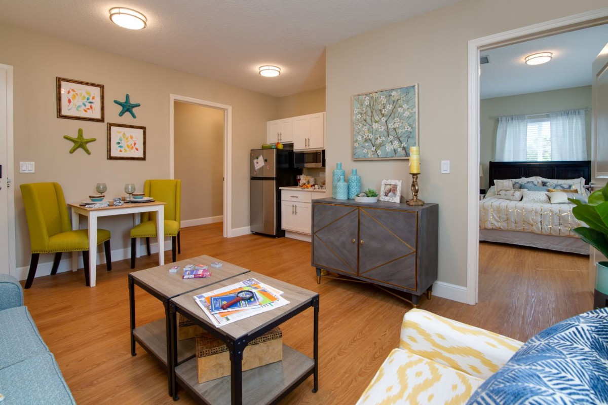 A modern living room and kitchen area in an apartment with stylish furniture and decor.