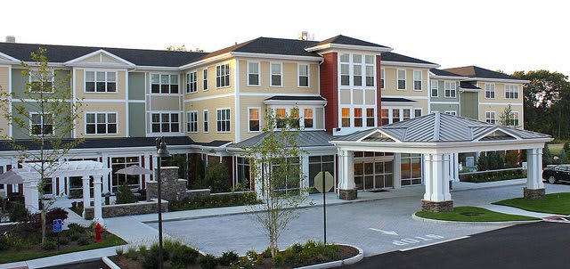 A modern residential building with a well-landscaped entrance.